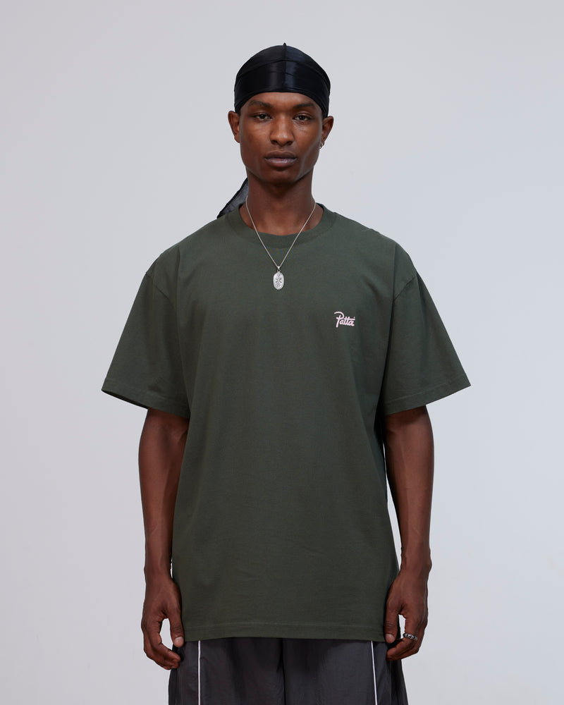 Front view of a model wearing the Patta Charm T-Shirt in Climbing Ivy green.
